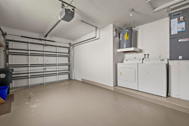 garage featuring washing machine and clothes dryer, water heater, and a garage door opener