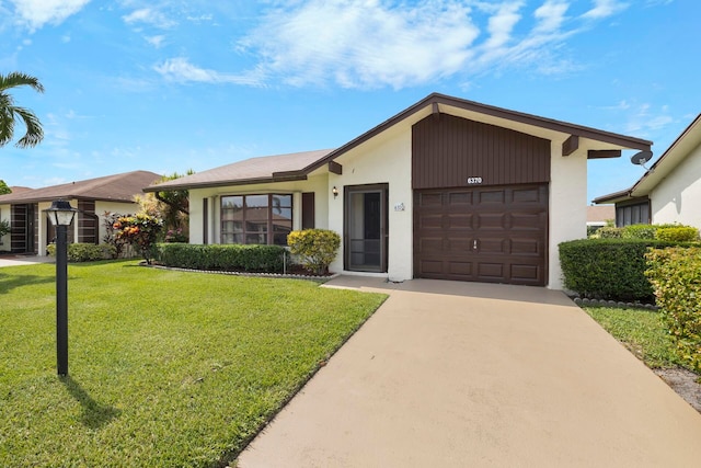 single story home featuring a garage and a front lawn