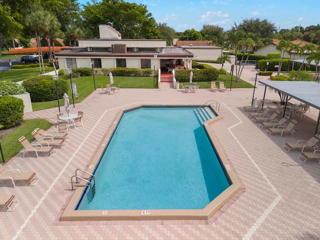 view of pool with a patio and a lawn