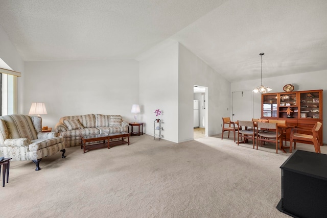 living room with a textured ceiling, high vaulted ceiling, an inviting chandelier, and light carpet