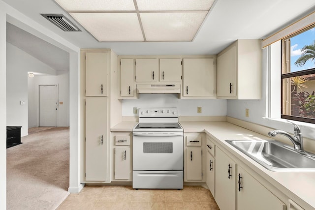 kitchen with light tile patterned flooring, cream cabinets, sink, and white range with electric stovetop