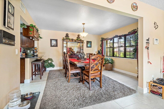 dining room with light tile patterned floors and a textured ceiling