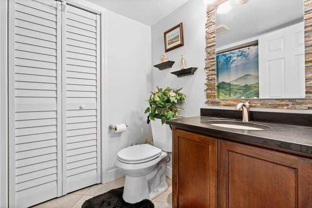 bathroom featuring vanity, toilet, and tile patterned flooring