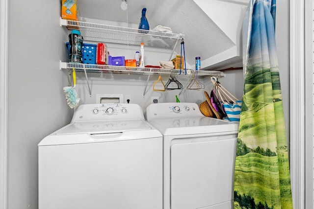 clothes washing area with washer and dryer and a textured ceiling