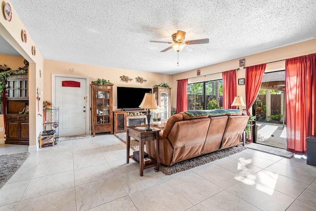 living room with a textured ceiling, ceiling fan, and tile patterned floors