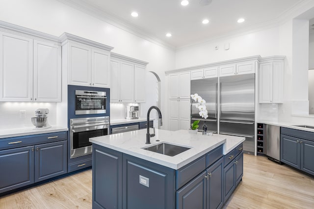 kitchen featuring backsplash, white cabinets, and an island with sink