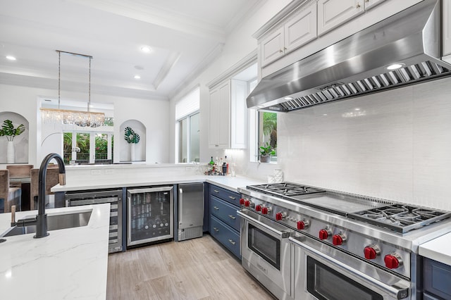 kitchen with blue cabinets, tasteful backsplash, beverage cooler, and range with two ovens