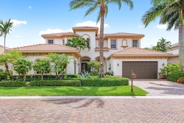 mediterranean / spanish house with a front yard and a garage