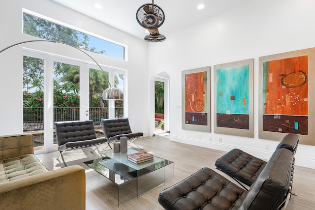 living room featuring light hardwood / wood-style flooring, a wealth of natural light, and a high ceiling