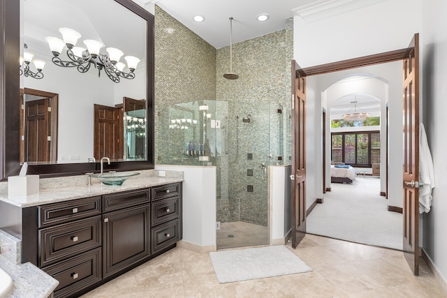 bathroom featuring a notable chandelier, tile patterned floors, walk in shower, and vanity