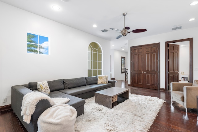 living room featuring ceiling fan and dark hardwood / wood-style floors