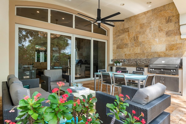 view of patio / terrace featuring area for grilling, exterior kitchen, ceiling fan, and an outdoor living space