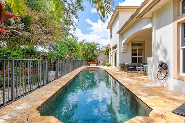 view of swimming pool featuring ceiling fan, a patio, and outdoor lounge area