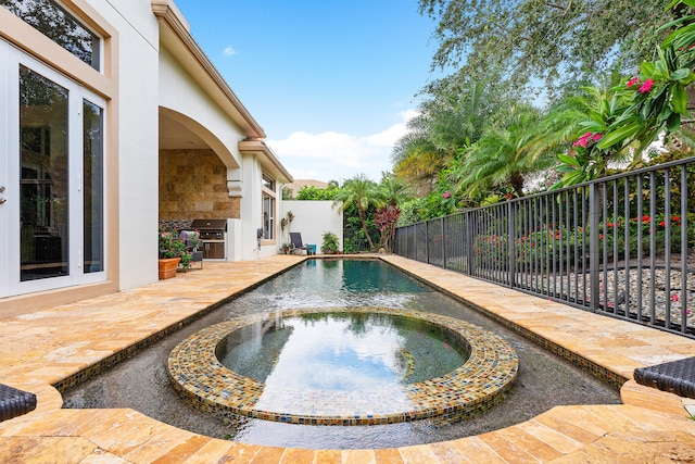 view of swimming pool featuring an in ground hot tub, a patio area, and a grill