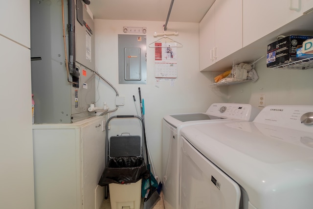 laundry room featuring heating unit, independent washer and dryer, cabinets, and electric panel