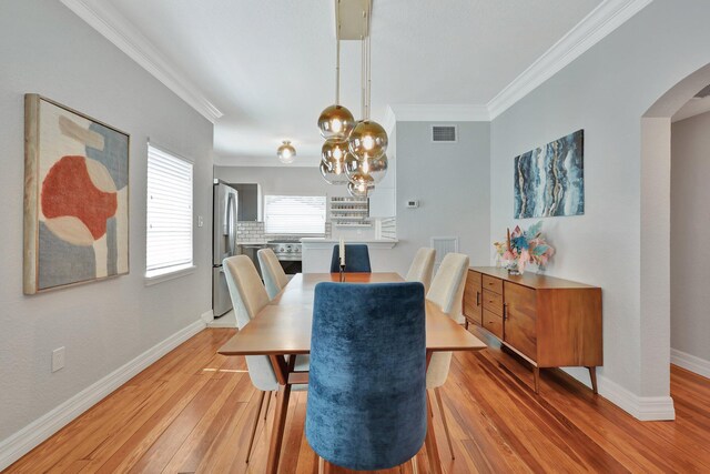 dining area featuring a notable chandelier, crown molding, and hardwood / wood-style flooring