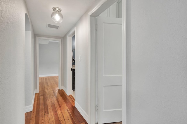 corridor with hardwood / wood-style flooring