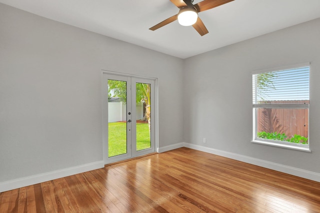 empty room featuring hardwood / wood-style floors, french doors, a wealth of natural light, and ceiling fan