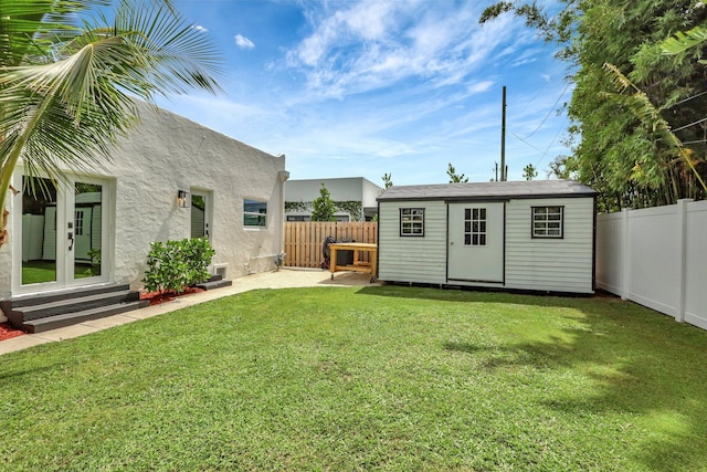 view of yard with french doors and a storage unit