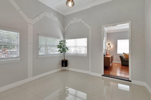 unfurnished room with crown molding, a healthy amount of sunlight, and tile patterned floors