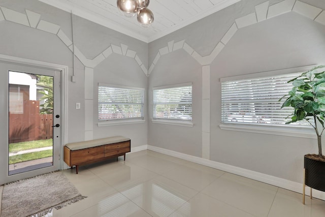 interior space with an inviting chandelier, light tile patterned floors, crown molding, and lofted ceiling