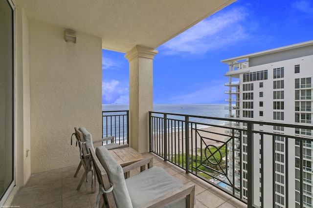 balcony with a beach view and a water view