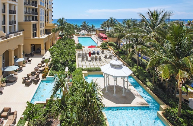 view of pool featuring a water view, a gazebo, and a patio