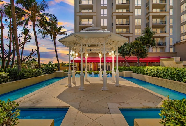 pool at dusk with a gazebo