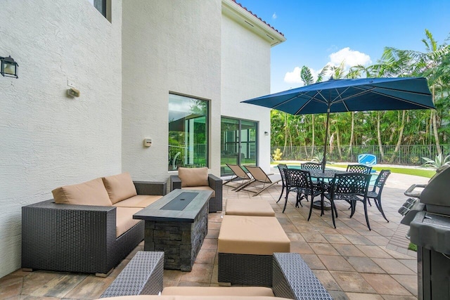 view of patio with an outdoor living space with a fire pit