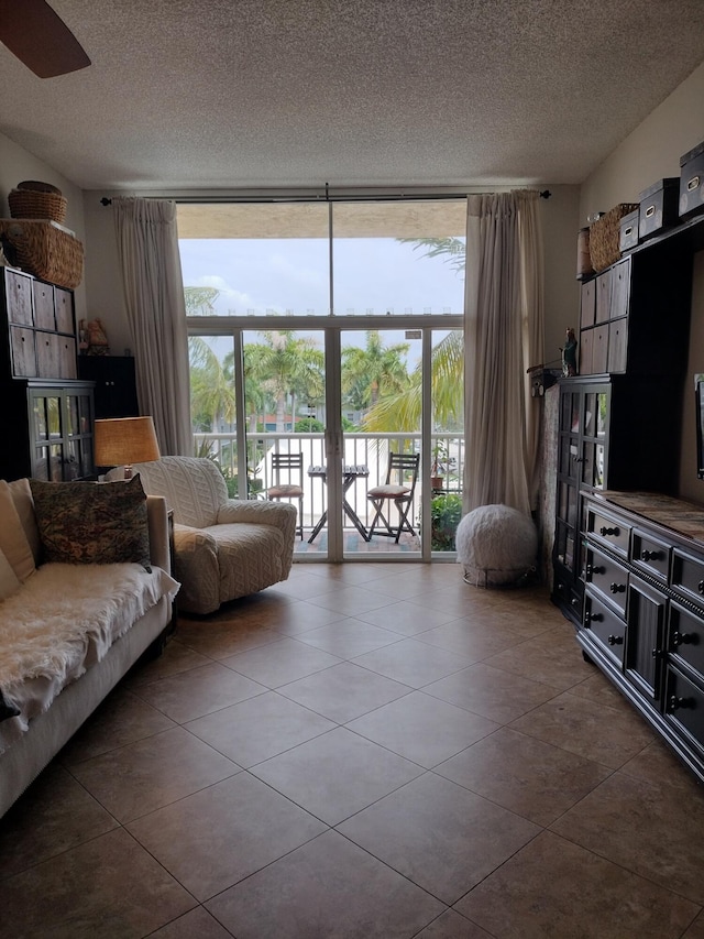 tiled living room with a textured ceiling and expansive windows