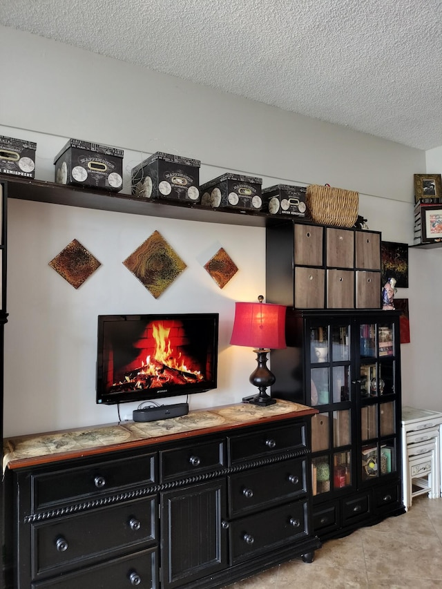 interior space with a textured ceiling and light tile patterned floors