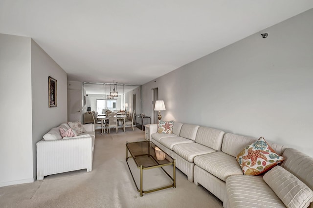 carpeted living room featuring an inviting chandelier