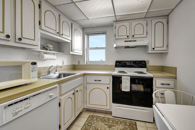 kitchen featuring sink, light tile patterned floors, a paneled ceiling, and white appliances