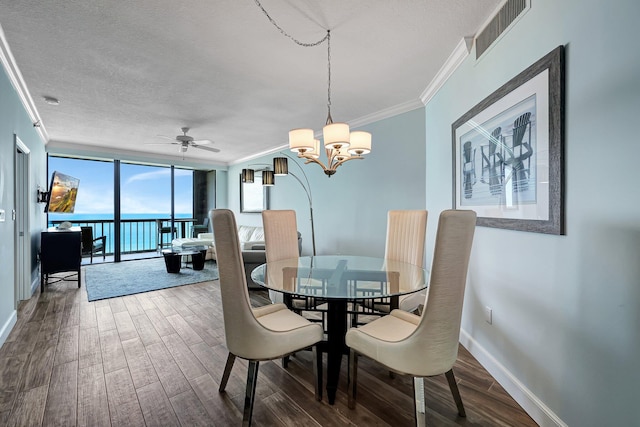 dining space with expansive windows, a textured ceiling, ornamental molding, hardwood / wood-style flooring, and ceiling fan with notable chandelier