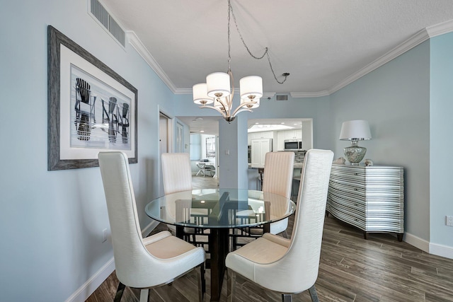 dining room featuring crown molding, dark hardwood / wood-style floors, and a notable chandelier