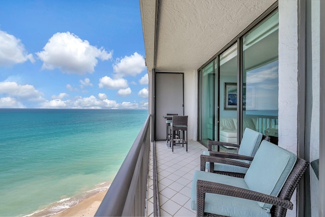 balcony with a water view and a beach view