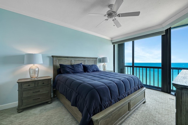 carpeted bedroom with a water view, a textured ceiling, ornamental molding, ceiling fan, and access to exterior