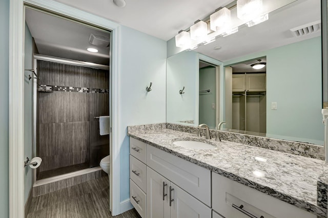 bathroom featuring vanity, an enclosed shower, and toilet