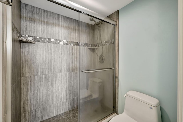 bathroom featuring toilet and an enclosed shower