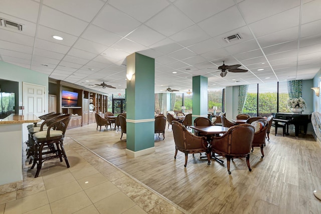 dining space featuring a paneled ceiling and light hardwood / wood-style floors