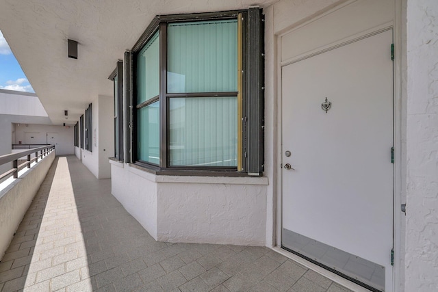 view of exterior entry with a balcony