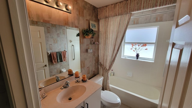 full bathroom featuring vanity, tiled shower / bath combo, and toilet