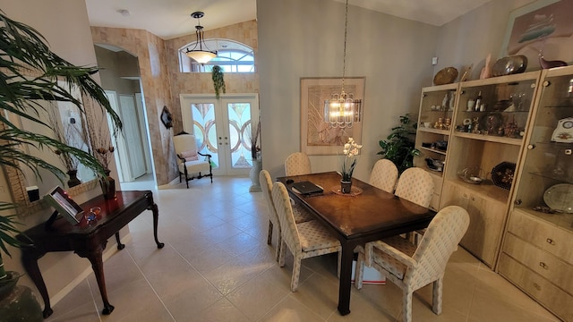 dining room featuring a notable chandelier, light tile patterned floors, french doors, and a high ceiling