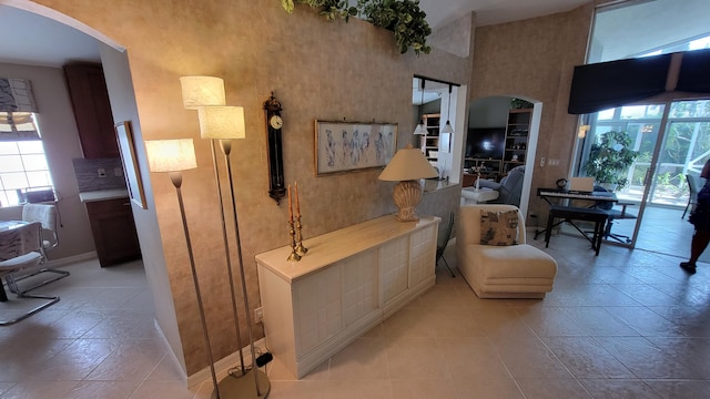 bathroom with tile patterned floors, a wealth of natural light, and a towering ceiling