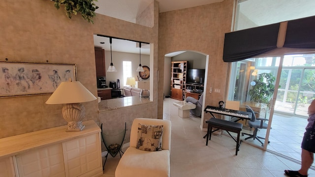 living room with a towering ceiling and light tile patterned floors