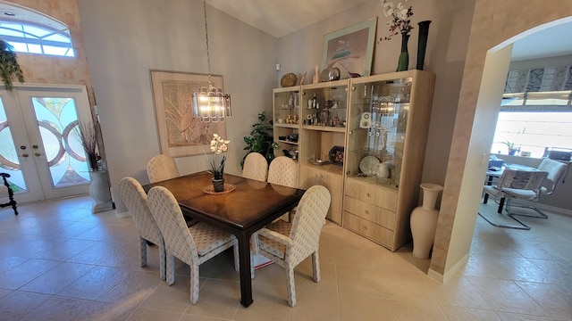 dining room with plenty of natural light, tile patterned floors, and a towering ceiling