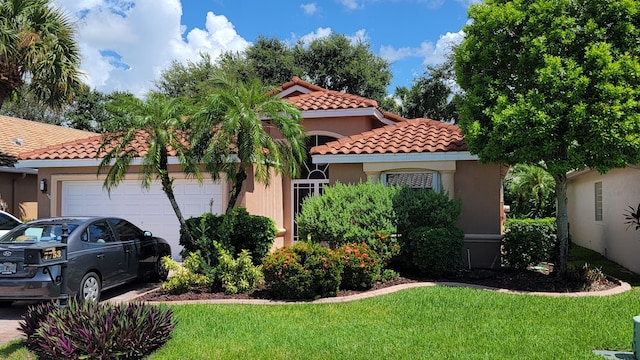 mediterranean / spanish house featuring a garage and a front yard