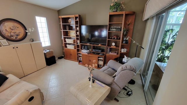 living room with light tile patterned flooring, plenty of natural light, and lofted ceiling