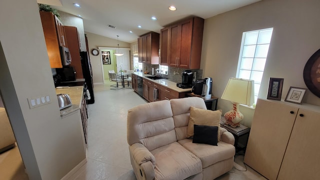 kitchen with sink, decorative backsplash, a healthy amount of sunlight, and light tile patterned floors