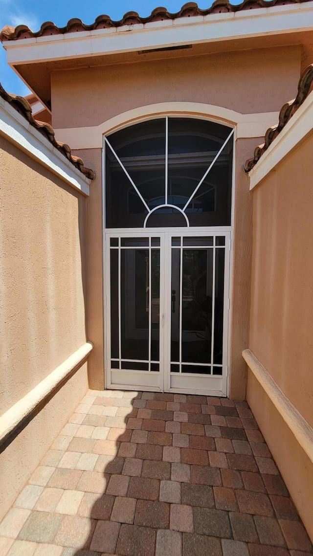 view of exterior entry with a patio